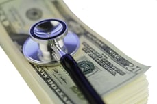 Stack of money and stethoscope Stack of money and stethoscope