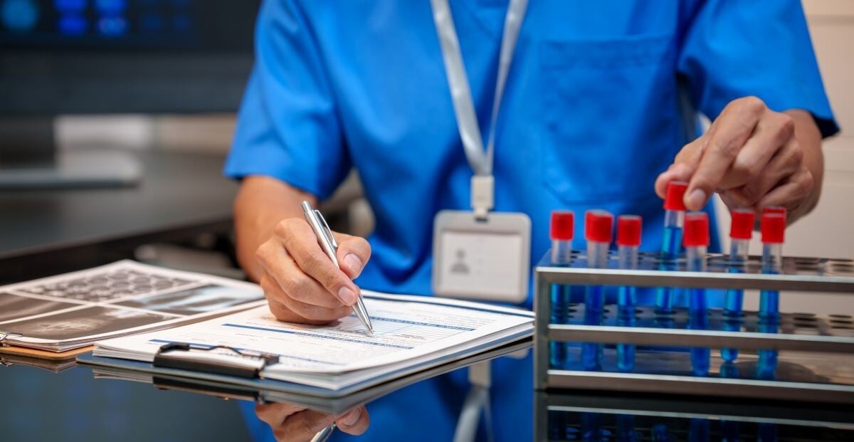 Medical laboratory technician with vials of blood for testing