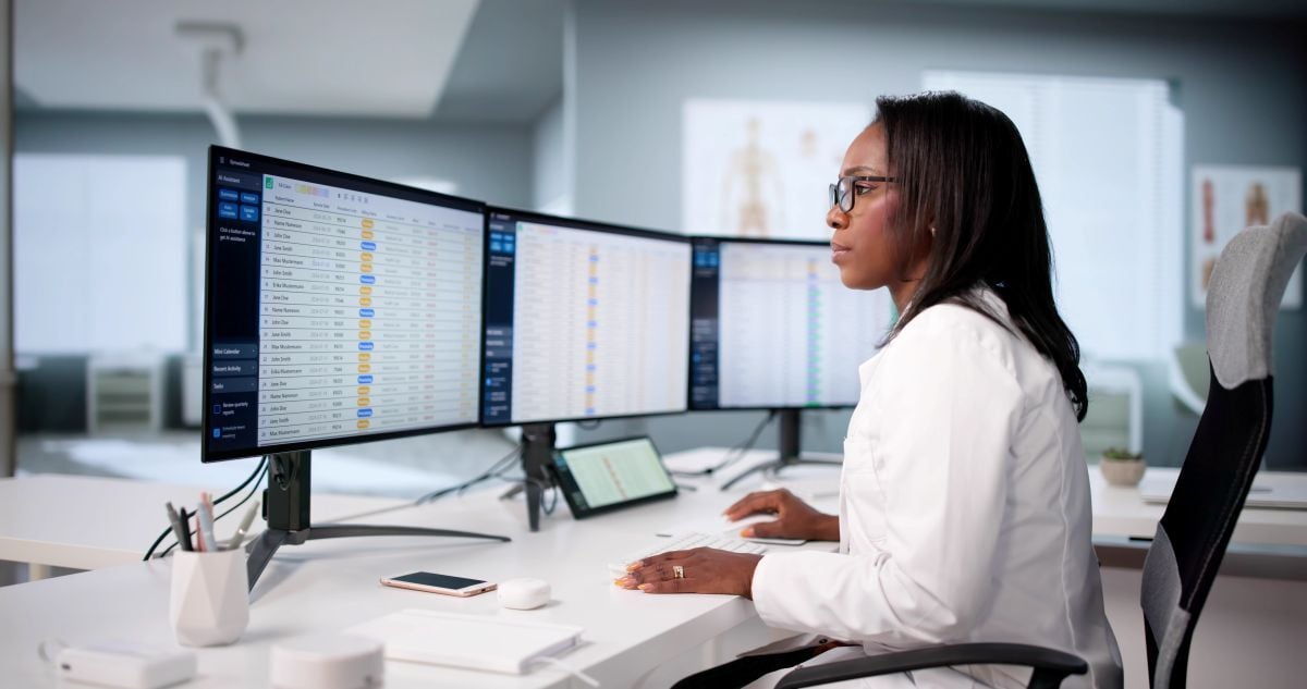 African American Woman Analyzing Medical Coding Data on a Computer Screen