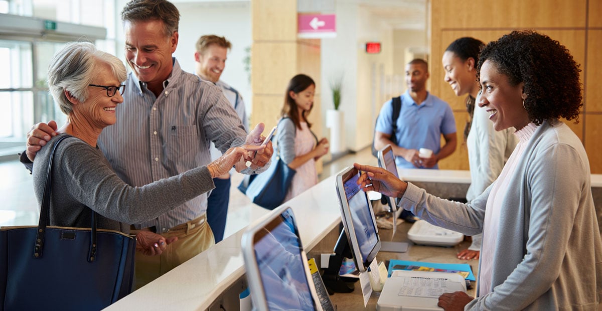 Physician office check-in desk with patients and staff 